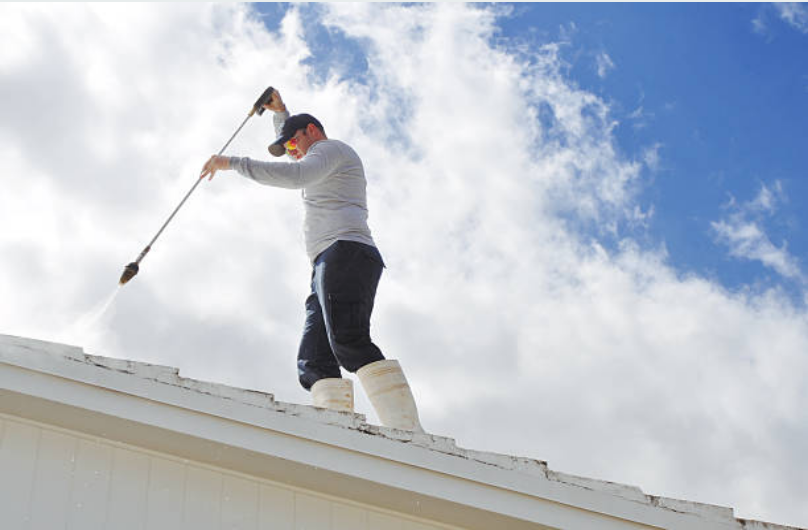 pressure washing the roof of a home